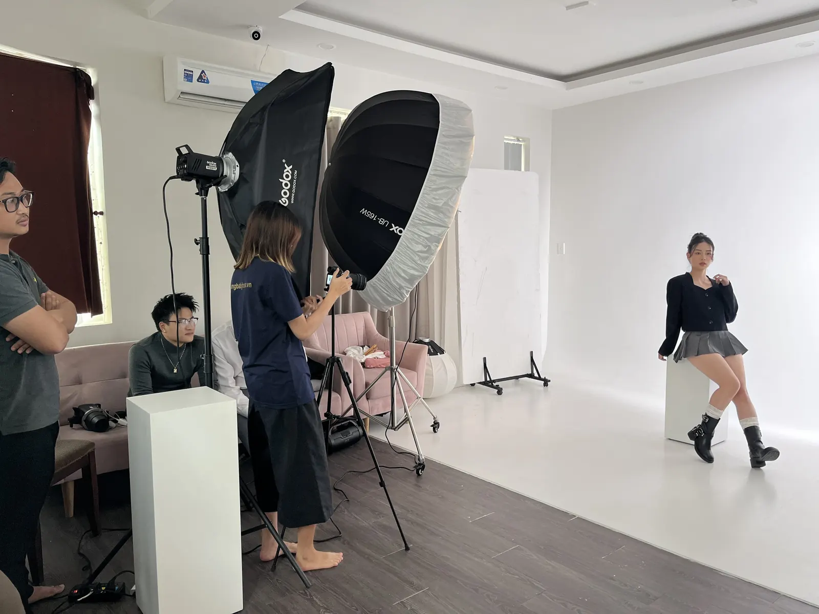 Ekip đang setup ánh sáng và chụp ảnh cho khách hàng tại studio chuyên nghiệp